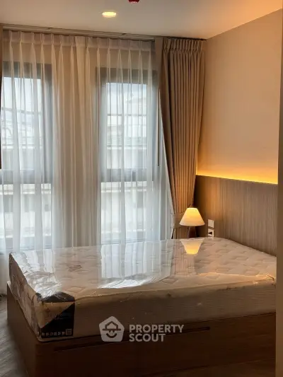 Modern bedroom with large windows and elegant lighting in a stylish apartment.