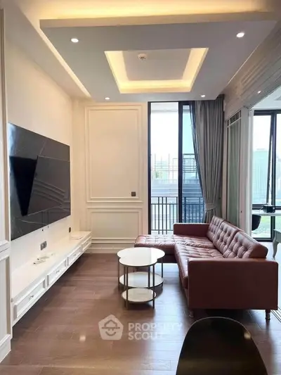 Modern living room with stylish leather sofa and large TV, featuring elegant ceiling design and natural light.