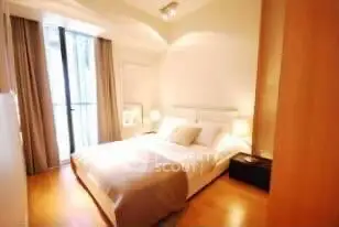 Elegant bedroom with natural light and modern decor in a luxury apartment.