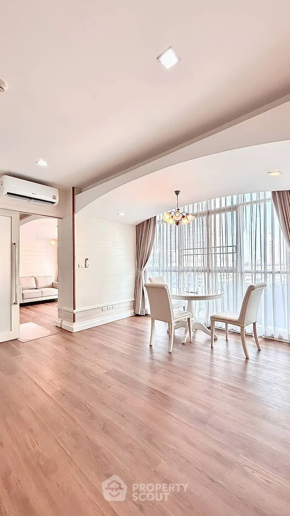 Spacious living room with elegant dining area and large windows for natural light.