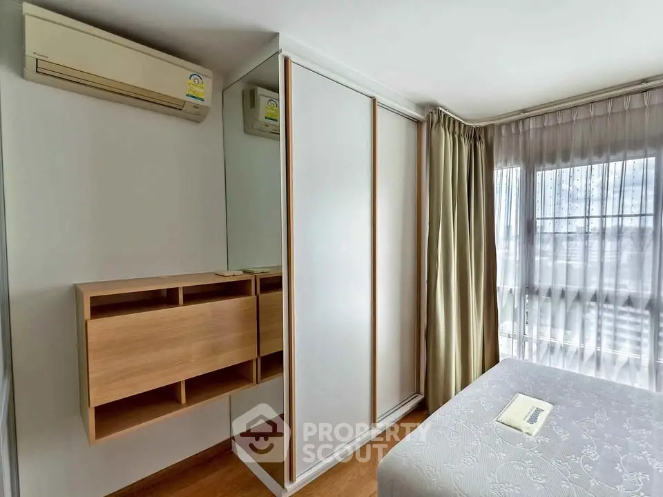 Modern bedroom with mirrored wardrobe and air conditioning unit
