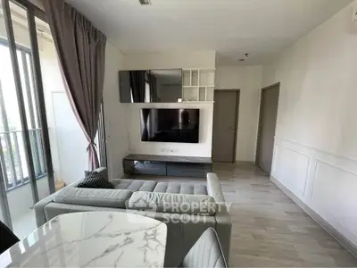 Modern living room with sleek design and large TV, featuring a cozy sofa and elegant marble table.