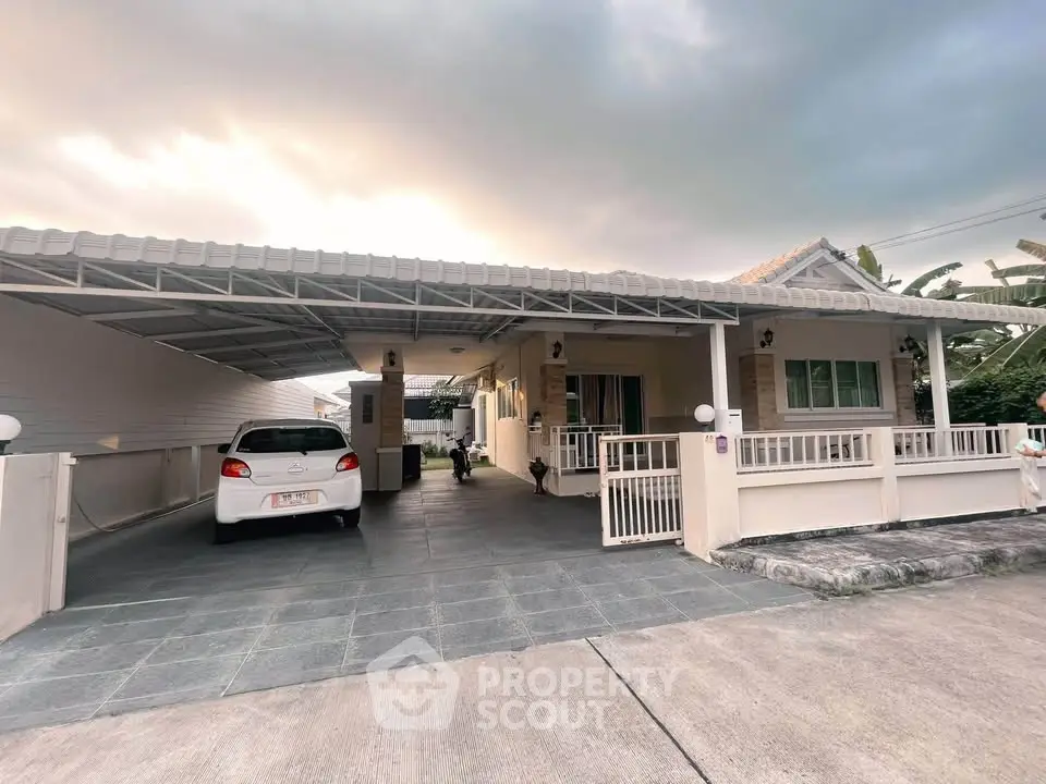 Charming single-story home with carport and spacious driveway in serene neighborhood.