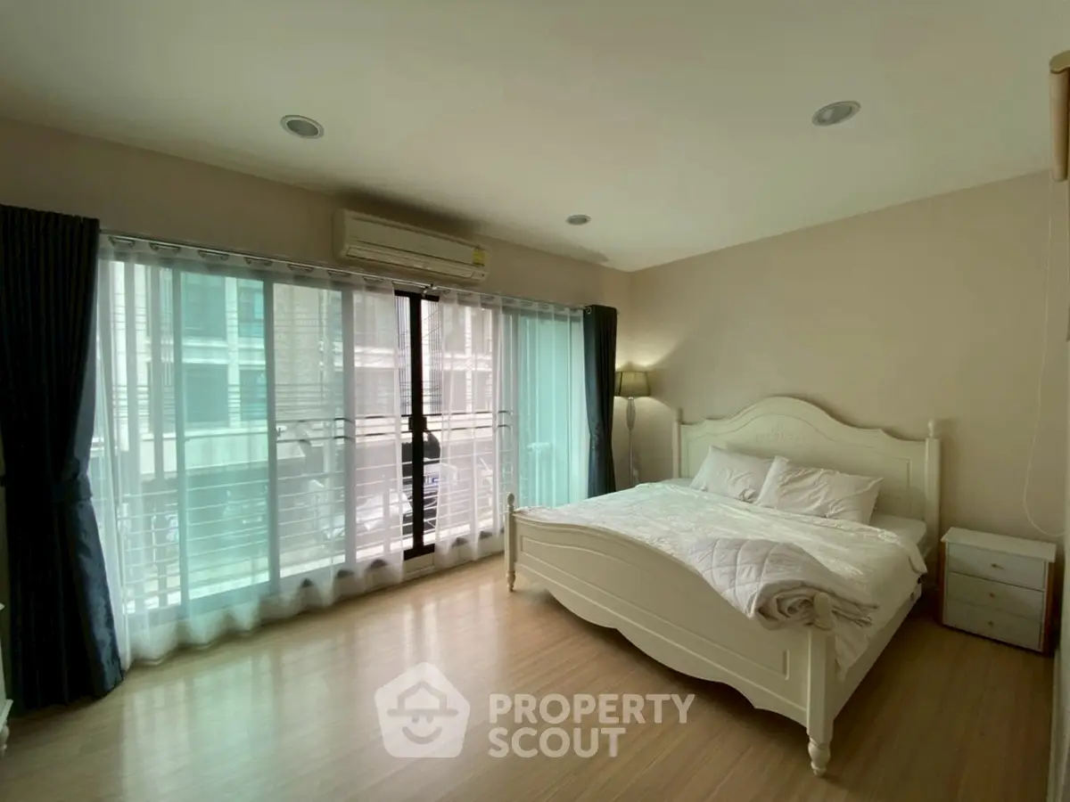 Spacious bedroom with large windows and elegant bed in modern apartment