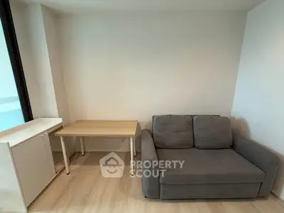 Cozy living room with modern gray sofa and wooden table, perfect for small spaces.