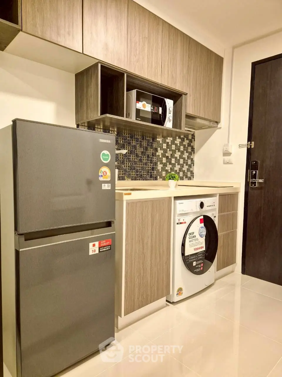 Modern kitchen with sleek appliances and stylish cabinetry in a contemporary apartment.