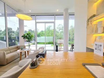 Modern living room with large windows and stylish furniture, offering a bright and inviting atmosphere.