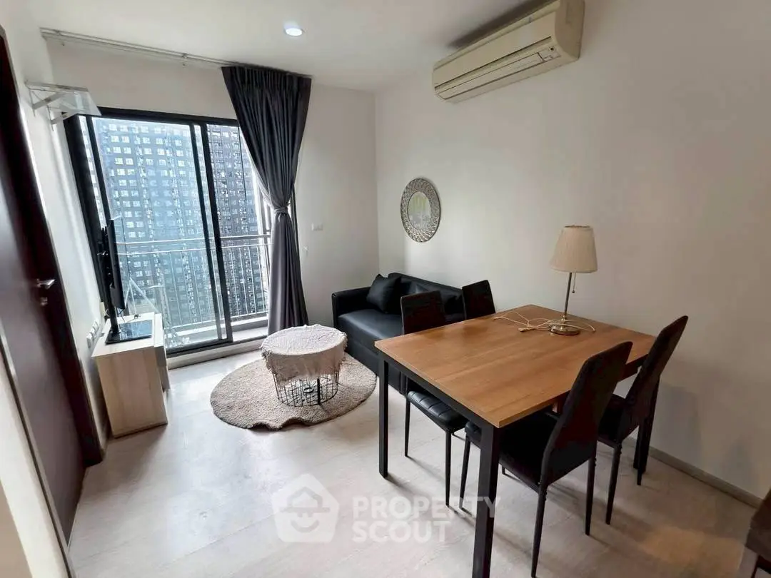 Modern living room with city view, featuring sleek furniture and air conditioning.