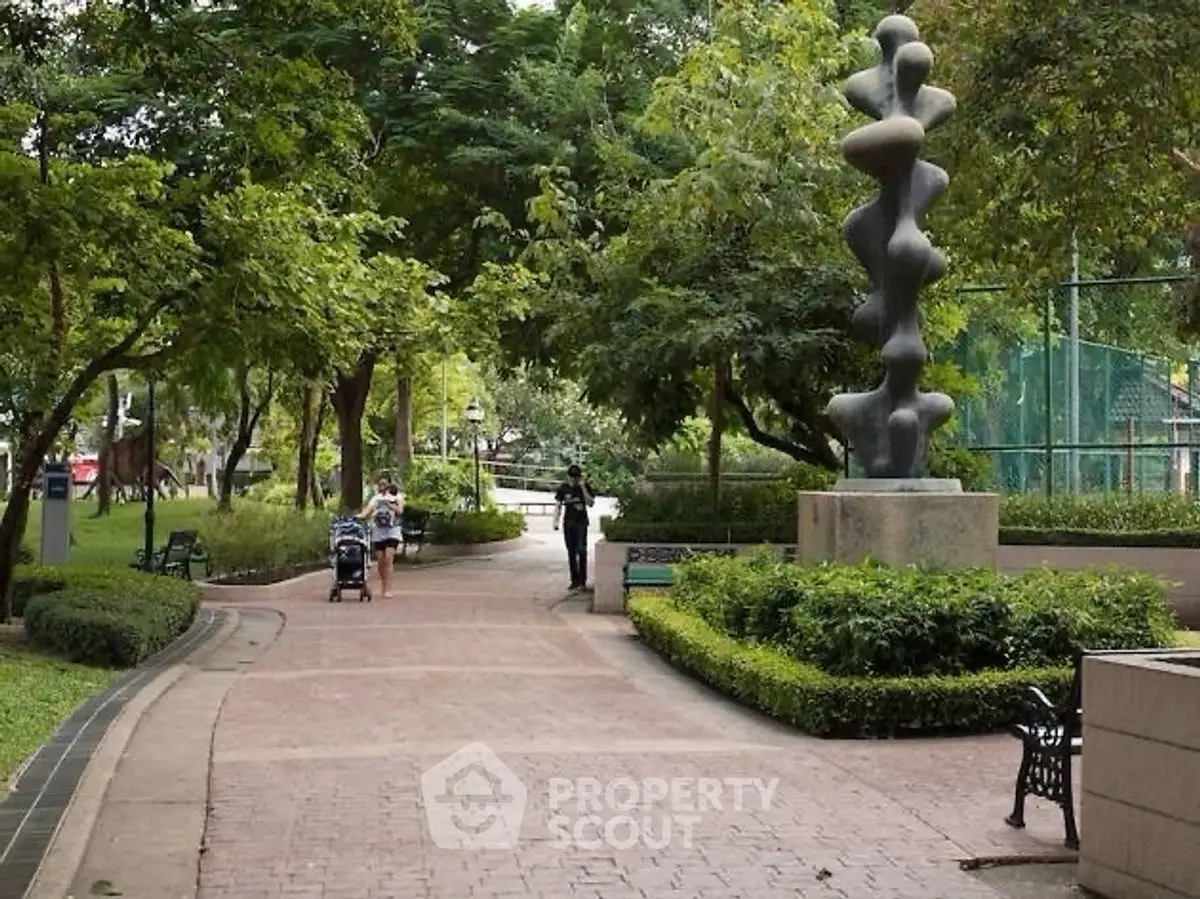 Beautifully landscaped garden with walking paths and modern sculpture in a serene residential area.