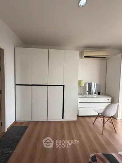 Modern bedroom with sleek white wardrobe and stylish chair