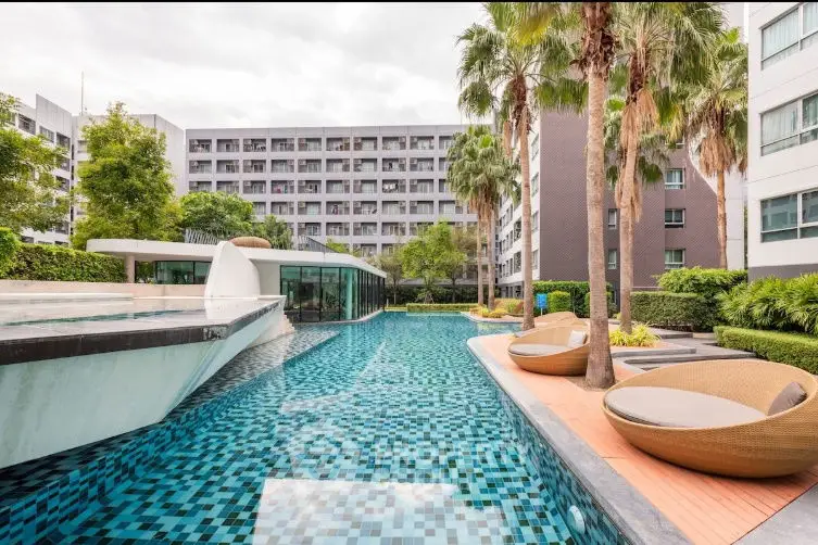 Luxurious apartment complex with modern pool and lush landscaping