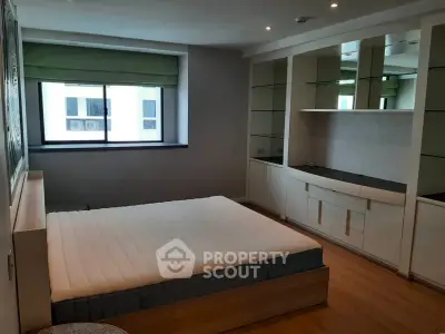 Spacious bedroom with built-in storage and large window for natural light.