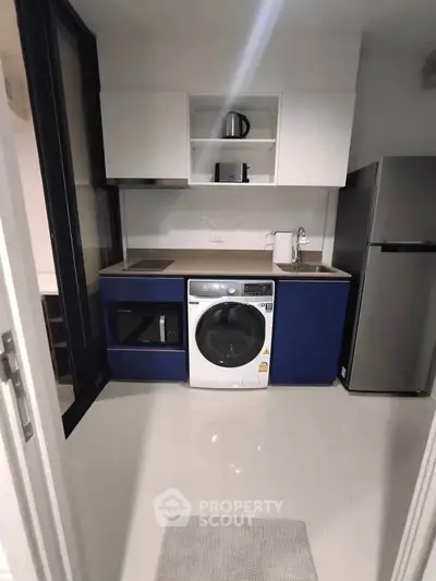 Modern compact kitchen with washing machine and sleek appliances