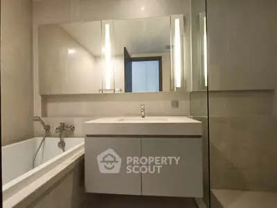Modern bathroom with sleek vanity and bathtub in luxury apartment