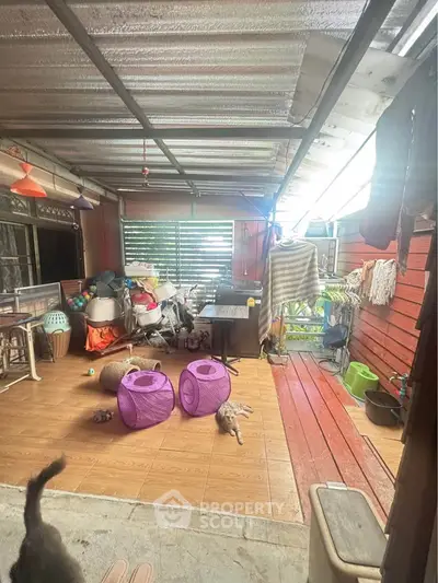 Spacious covered patio with wooden flooring and ample natural light, perfect for outdoor relaxation.