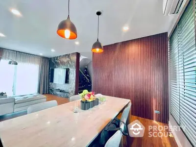 Modern dining area with stylish lighting and elegant decor in a spacious living room.