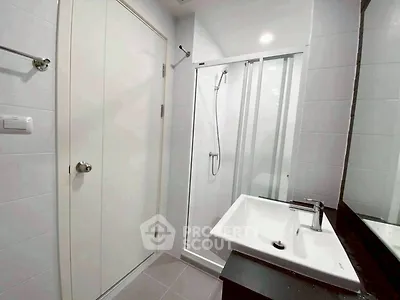 Modern bathroom with sleek shower and stylish sink in contemporary apartment.