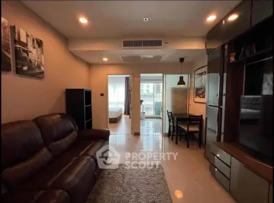 Modern living room with leather sofa and dining area in open layout apartment.