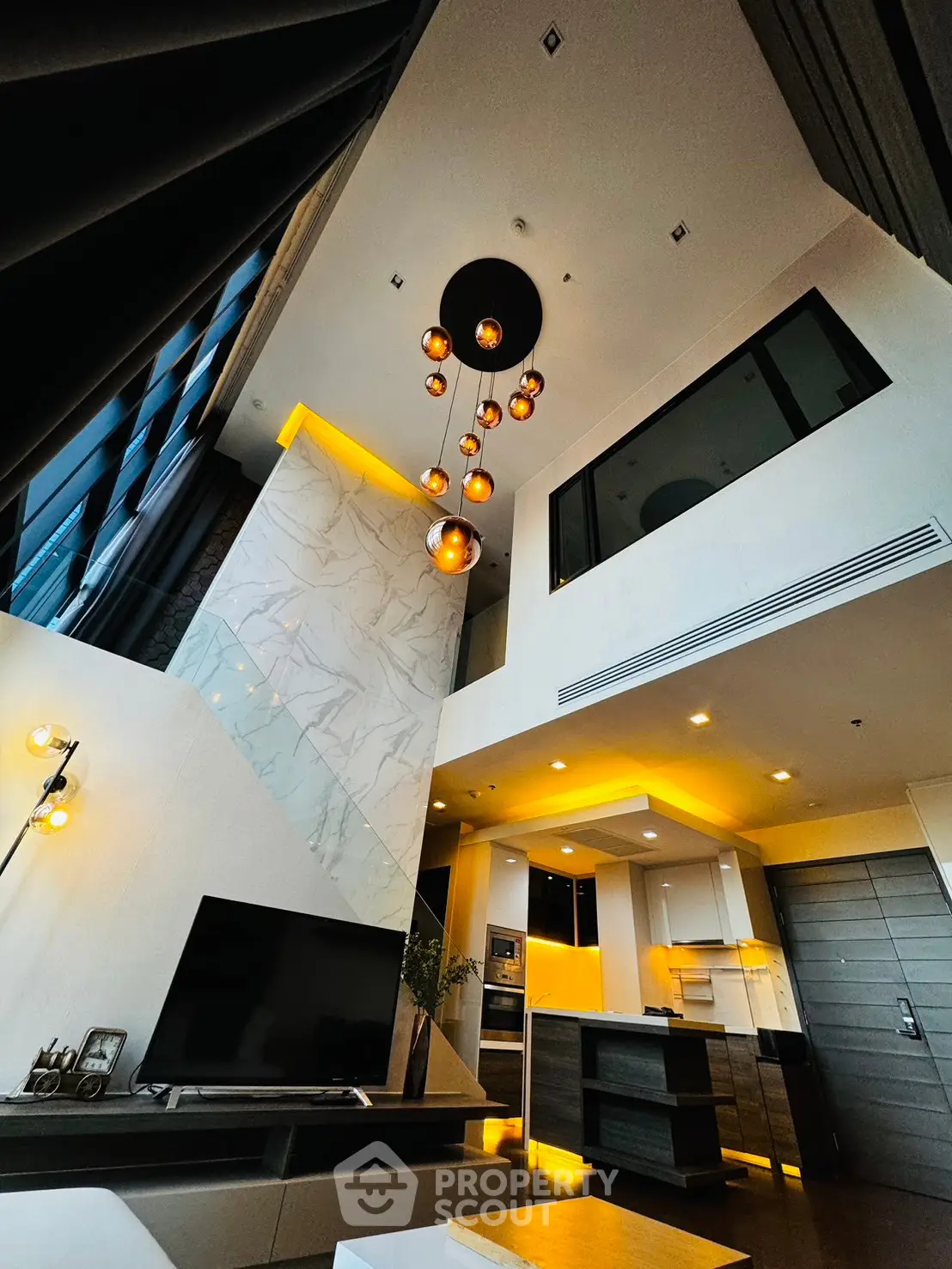 Luxurious modern living room with high ceiling and elegant lighting in a stylish apartment.