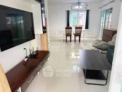 Spacious living room with modern furniture and large TV, perfect for family gatherings.