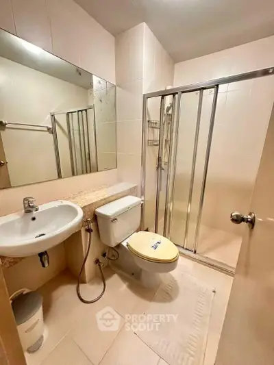 Modern bathroom with glass shower enclosure and sleek fixtures