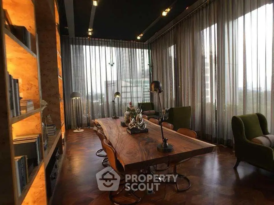Luxurious study room with elegant wooden table and floor-to-ceiling windows offering city views.