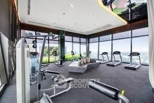 Luxury gym with panoramic city views and modern fitness equipment.