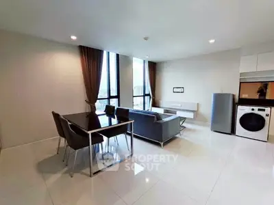 Modern living room with dining area, sleek furniture, and large windows in a stylish apartment.
