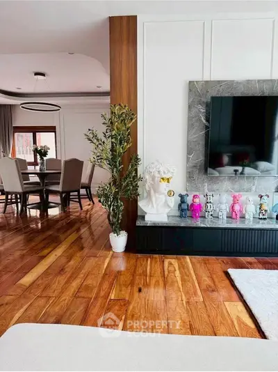 Elegant living room with wooden floors, modern decor, and dining area view