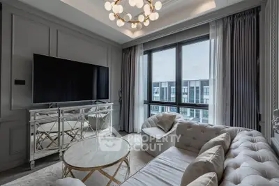 Luxurious living room with modern decor and large windows offering city views.