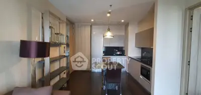 Modern kitchen with sleek design and dining area in open layout apartment.