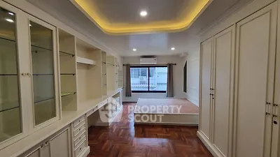 Spacious bedroom with elegant built-in storage and large window view