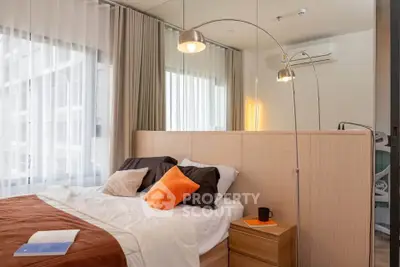 Modern bedroom with stylish decor and large windows in a contemporary apartment.
