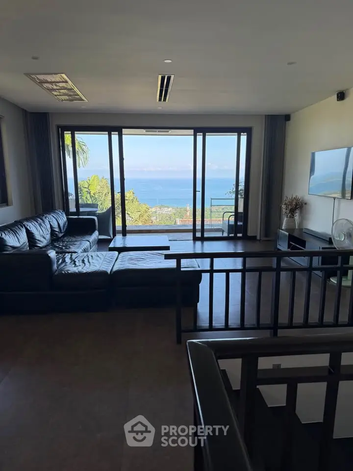 Luxurious living room with ocean view and modern black leather sofa