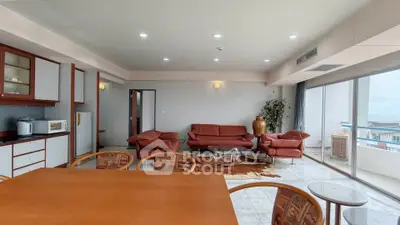 Spacious living room with modern furniture and large windows offering a stunning view.
