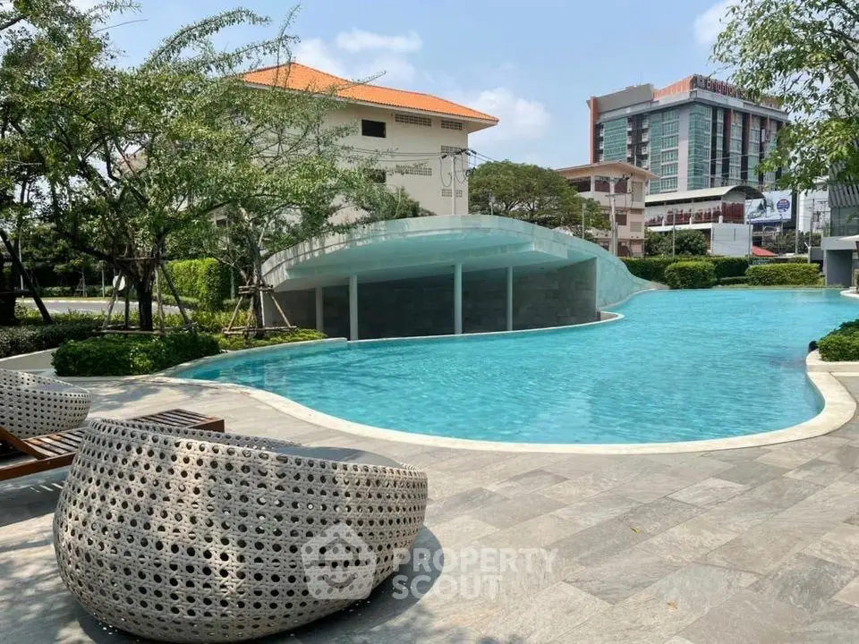 Luxurious outdoor pool area with modern seating and lush greenery, perfect for relaxation and leisure.