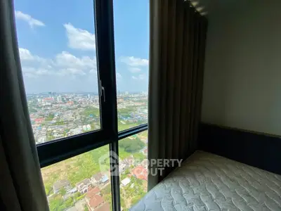 Stunning city view from a high-rise bedroom window, showcasing urban landscape and bright skies.