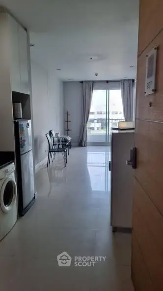 Modern apartment entrance leading to a bright living area with balcony view.