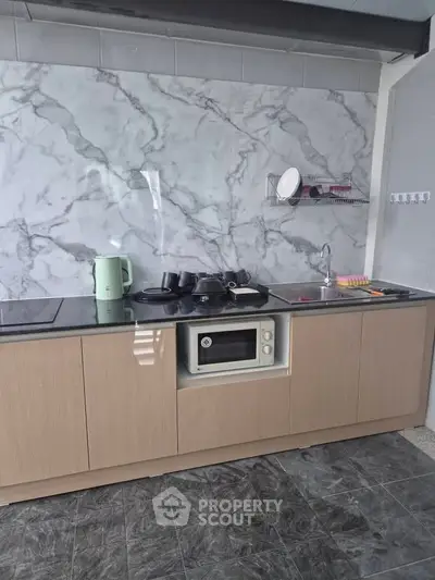 Modern kitchen with marble backsplash and built-in appliances