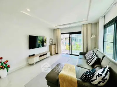 Modern living room with sleek design and large windows offering natural light.