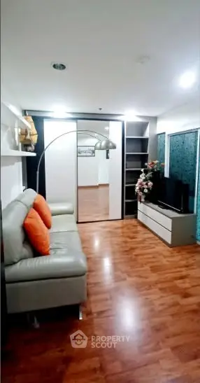 Spacious living room with modern decor and wooden flooring, perfect for relaxation and entertainment.