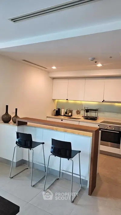 Modern kitchen with sleek design, featuring an open layout and stylish bar seating.