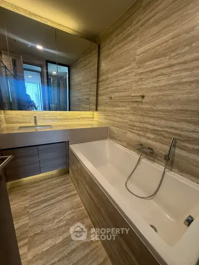 Luxurious bathroom with elegant marble design and modern bathtub.