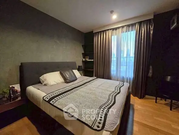 Cozy bedroom with modern decor and large window for natural light.