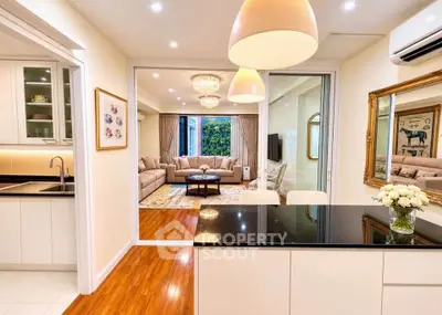 Luxurious open-plan kitchen and living room with elegant decor and modern lighting.