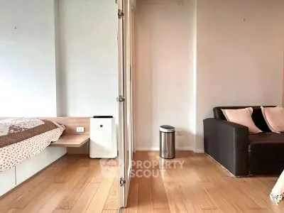 Modern interior with wooden flooring, cozy sofa, and stylish decor in a compact living space.