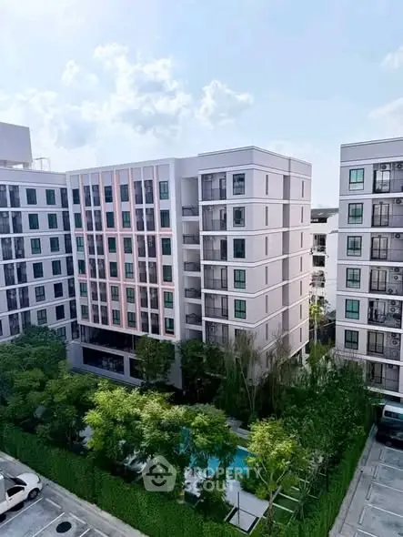 Modern apartment complex with lush greenery and pool view