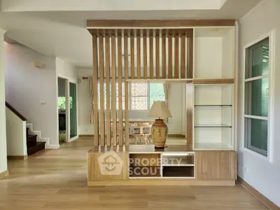 Elegant open-plan living area with wooden flooring and stylish partition