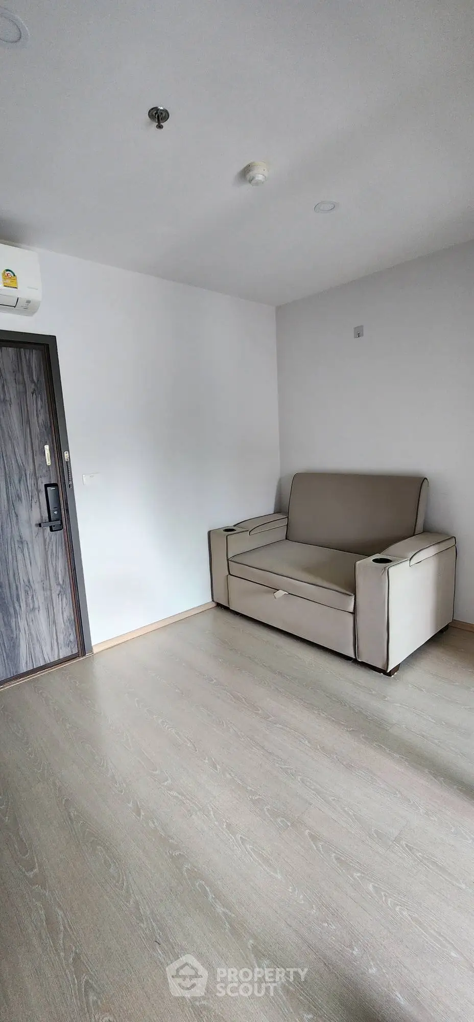 Minimalist living room with modern sofa and wooden flooring in a bright apartment.