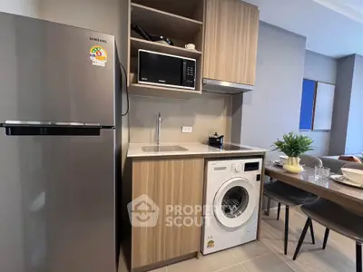 Modern compact kitchen with washing machine and microwave in stylish apartment